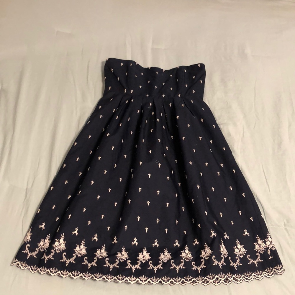 Strapless navy dress with stitched white detail.